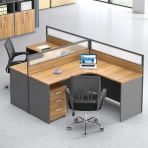A two-person L-shaped office workstation unit crafted from light wood-toned melamine MDF and dark grey panels, with white and grey privacy partitions, designed for an open office environment.